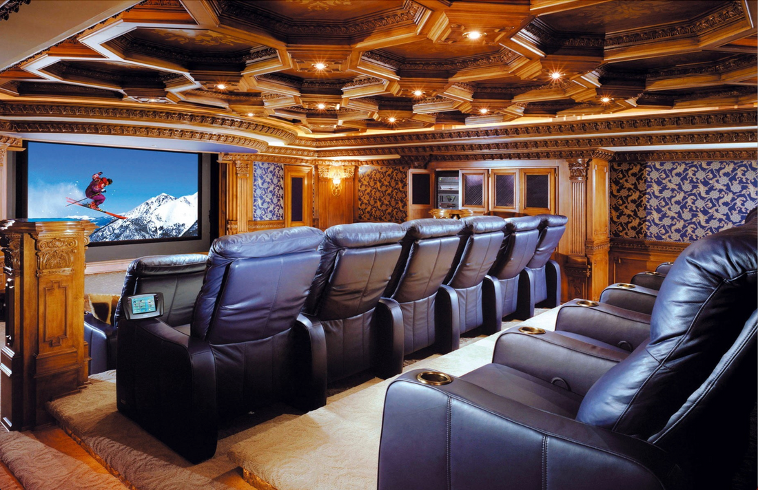 Luxurious home theater with leather recliner seats, ornate wooden decor, and a large screen displaying a skier in action, creating an immersive cinematic experience in a smart home setting.
