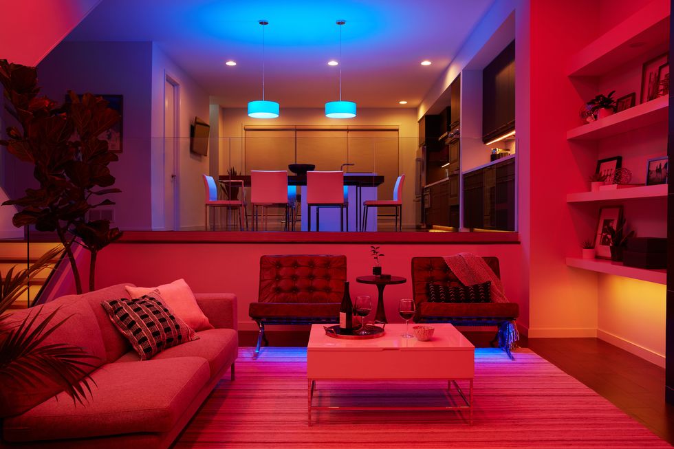 Smart lighting in a modern living room, featuring adjustable colored lights that create a vibrant and cozy ambiance, highlighting the flexibility and mood-setting capabilities of smart home lighting systems.